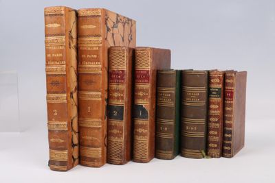 several old books are lined up in a row on a white surface