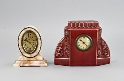 two clocks sitting next to each other on a table