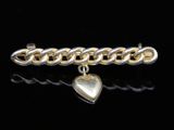 a close up of a gold and silver bracelet with a heart charm