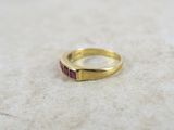 a close up of a gold ring with a red stone