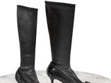 des bottes à talons hauts en cuir noir posées sur une surface en marbre