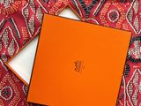 an orange box sitting on top of a red and white cloth