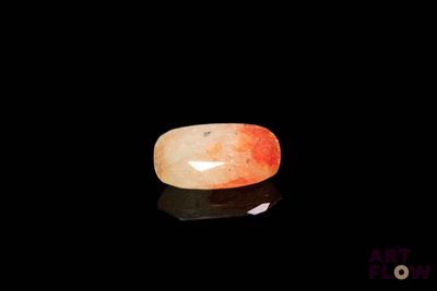 an image of a red and white stone on a black surface