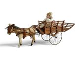 a figurine of a woman riding in a horse drawn carriage