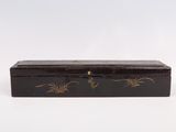 an old wooden box with a black and gold design on it