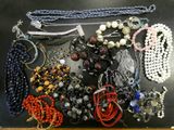 many different types of necklaces and bracelets laid out on a table