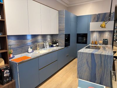 a kitchen with blue cabinets and a marble counter top