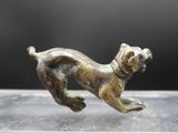 un gros plan sur une figurine représentant un chien en train de courir, posée sur une table