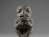 a close up of a statue of a monkey on a gray background