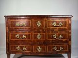 une commode ancienne avec des poignées en laiton et des tiroirs