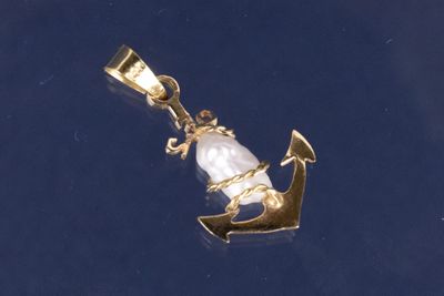 une image représentant un pendentif en forme d'ancre en or et de perle sur fond bleu