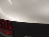 the rear end of a white car with a black tail light