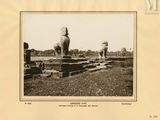 an old photo of a couple of statues sitting on top of a grass covered field