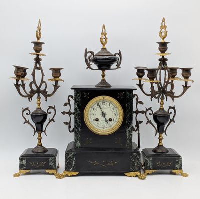 une image représentant une horloge et quatre bougies posées sur une table