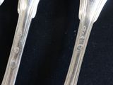 two spoons and a fork on a black table