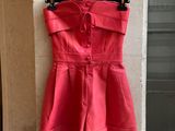une robe rouge accrochée à un mur devant un immeuble