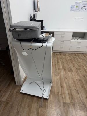 a laptop sitting on top of a stand in a room