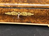 an image of a wooden box with a brass handle on a black surface