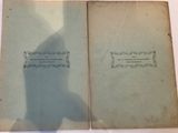an old book sitting on top of a table next to a shadow of a person