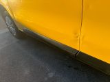 yellow car parked on the side of the road in a parking lot