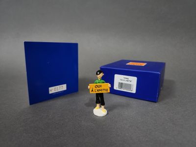 la figurine tient une pancarte devant une boîte bleue