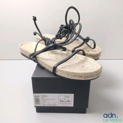 Les chaussures se trouvent dans la boîte posée sur la surface blanche.