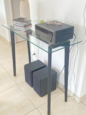 une table en verre sur laquelle est posée une chaîne hi-fi