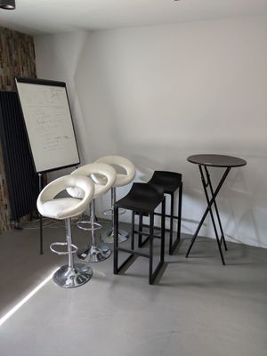 trois tabourets et une table dans un coin de la pièce