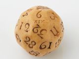 dice with numbers carved on it on a white surface