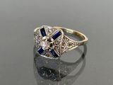 a close up of a diamond and sapphire ring on a table