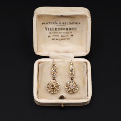 une photo d'une paire de boucles d'oreilles dans une boîte posée sur une table