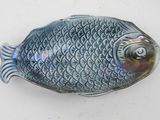 a small blue fish shaped object on a white surface