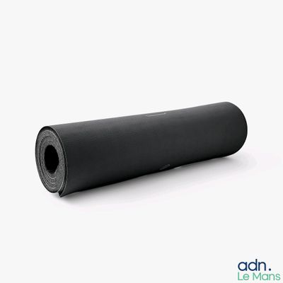 le rouleau de caoutchouc noir est posé sur une surface blanche
