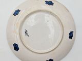 a white plate with blue flowers on it on a white surface