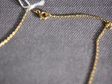 a close up of a gold chain bracelet on a table