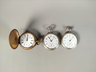 three different types of pocket watches are displayed on a white surface