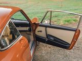 an orange car with its door open sitting on the side of the road