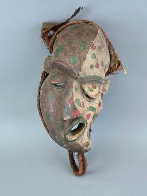 une image d'un masque en bois accroché au mur