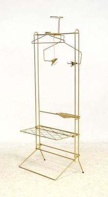 a gold clothes rack with three hangers on it