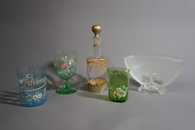 Des bouteilles et des verres sont posés sur une surface blanche, à côté d'un saladier