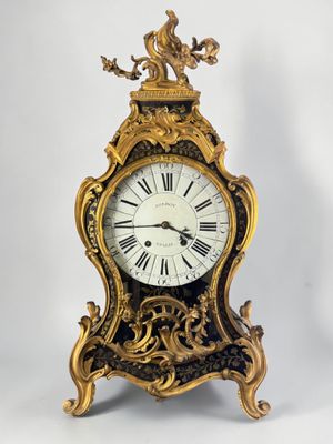 a gold clock that is sitting on a white surface