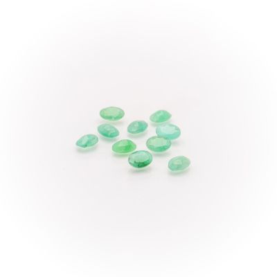 a group of green glass beads on a white surface