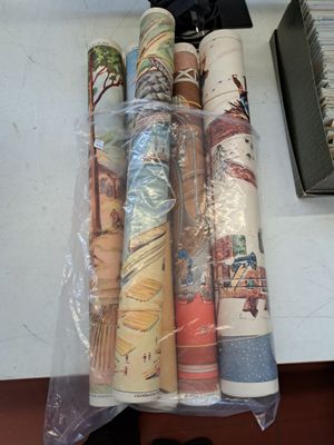 many rolls of fabric on a table next to a pair of shoes