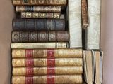 an open cardboard box filled with lots of books sitting on top of each other