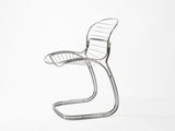 une chaise en métal posée sur une surface blanche