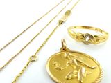 un collier, une bague et un bracelet plaqués or posés sur un fond blanc