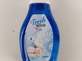 un gros plan d'une bouteille contenant un liquide posée sur une surface blanche