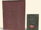 an old book sitting next to a small book on a white surface