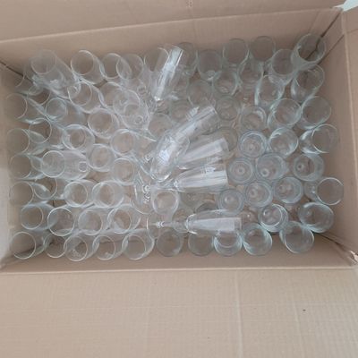 a cardboard box filled with plastic cups and a bunch of toothbrushes