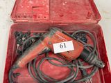 une boîte rouge contenant une perceuse et d'autres outils